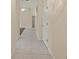 Hallway with neutral walls, tile flooring, and doorway into another room at 3311 39Th W Pl, Bradenton, FL 34205