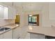 Bright kitchen featuring tile flooring, breakfast bar, sliding door, and modern lighting at 3311 39Th W Pl, Bradenton, FL 34205
