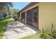 Exterior view of screened lanai with lush lawn featuring tropical plants and patio at 3311 39Th W Pl, Bradenton, FL 34205