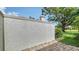 Small brick patio featuring a stucco wall with tree and lush landscape in background at 3317 Highlands Bridge Rd # 61, Sarasota, FL 34235