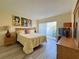 Bedroom with yellow comforter, wood-look floors, and bright lamps at 3500 El Conquistador Pkwy # 347, Bradenton, FL 34210
