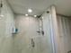 Walk-in shower featuring marble-style tiles, glass door, and dual shower heads at 3500 El Conquistador Pkwy # 347, Bradenton, FL 34210