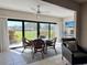 Bright sunroom featuring a glass-top dining table, wicker chairs, and serene outdoor views at 3500 El Conquistador Pkwy # 347, Bradenton, FL 34210