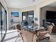 Sunroom with a glass table, wicker chairs, and bright sunlight coming from sliding glass doors at 3500 El Conquistador Pkwy # 347, Bradenton, FL 34210