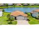 Beautiful front view of a home with three car garage, manicured lawn, and landscaping near a lake at 3504 Big Sky Way, Bradenton, FL 34211