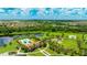 Stunning aerial view of the community featuring a resort-style pool, lake, tennis court, and lush landscaping at 3504 Big Sky Way, Bradenton, FL 34211