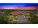 Stunning sunset view of single-Gathering home with lake view and lush landscaping with a three-car garage at 3504 Big Sky Way, Bradenton, FL 34211