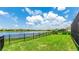 Lush backyard features a serene lake view, enclosed by a black iron fence at 3504 Big Sky Way, Bradenton, FL 34211