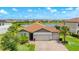 Charming single-story home with a three-car garage, lush landscaping, and a brick-paved driveway at 3504 Big Sky Way, Bradenton, FL 34211