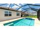 Outdoor pool and spa are surrounded by a screened enclosure and tiled patio at 3504 Big Sky Way, Bradenton, FL 34211