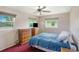 Bedroom with two windows, ceiling fan, and two wooden chests of drawers at 3621 S Lockwood Ridge Rd, Sarasota, FL 34239