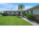 Landscaped front yard with a vibrant lawn leading to the inviting entrance of the home at 3621 S Lockwood Ridge Rd, Sarasota, FL 34239