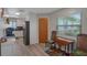 Bright kitchen featuring modern appliances, white cabinetry and a wooden dining table set near a sunny window at 3621 S Lockwood Ridge Rd, Sarasota, FL 34239