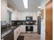 Well-lit kitchen features stainless steel appliances, granite counters, tile backsplash and white cabinetry at 3621 S Lockwood Ridge Rd, Sarasota, FL 34239
