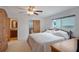 Bright bedroom features a queen bed, ceiling fan, and an ensuite bathroom at 3621 S Lockwood Ridge Rd, Sarasota, FL 34239