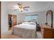 Bright bedroom features a queen bed, ceiling fan, and an ensuite bathroom at 3621 S Lockwood Ridge Rd, Sarasota, FL 34239