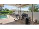 Outdoor barbecue and patio area features a pool and multiple grills at 3621 S Lockwood Ridge Rd, Sarasota, FL 34239