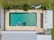 Aerial view of a rectangular backyard pool with inflatables, patio furniture, and lush landscaping at 3621 S Lockwood Ridge Rd, Sarasota, FL 34239