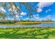 Scenic pond view with lush green surroundings, under a bright blue sky with scattered clouds at 3881 Chatsworth Greene Ct # 20, Sarasota, FL 34235
