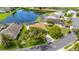 Aerial view of a home with a screened-in pool, mature trees, and lake access at 4120 51St W Dr, Bradenton, FL 34210