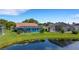 Backyard featuring a screened-in pool, lush lawn, and scenic views of the adjacent lake at 4120 51St W Dr, Bradenton, FL 34210