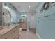 Bright bathroom features double vanities, modern lighting, and walk-in shower with glass door and decorative tiles at 4120 51St W Dr, Bradenton, FL 34210