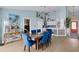 Open-concept living space boasting a dining room with blue chairs and views of the kitchen and bedroom at 4120 51St W Dr, Bradenton, FL 34210