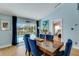 Elegant dining room featuring a wood table, blue velvet chairs, and a sliding glass door to the pool area at 4120 51St W Dr, Bradenton, FL 34210