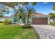 Charming single-story home features a well-manicured lawn, brick driveway, and lush tropical landscaping at 4120 51St W Dr, Bradenton, FL 34210