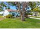 The home boasts a bright facade, green lawn, manicured landscaping, and beautiful shade trees at 4120 51St W Dr, Bradenton, FL 34210