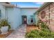 Charming home entrance with paver walkway, lush landscaping, and a serene water feature at 4120 51St W Dr, Bradenton, FL 34210