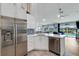 Contemporary kitchen with white cabinets, stainless steel appliances, and a breakfast bar overlooking the pool area at 4120 51St W Dr, Bradenton, FL 34210