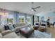 Bright living room with blue accents, comfortable seating, and views of the pool area through large windows at 4120 51St W Dr, Bradenton, FL 34210