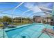 A screened-in pool area boasts comfortable lounge chairs, serene water, and a scenic view at 4120 51St W Dr, Bradenton, FL 34210