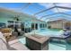 A screened-in pool area features furniture, a BBQ grill, and a serene atmosphere at 4120 51St W Dr, Bradenton, FL 34210