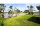 Lush green backyard with a white fence bordering a scenic lake, providing privacy and tranquility at 4194 Banbury Cir, Parrish, FL 34219