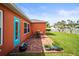Backyard featuring a brick patio with outdoor seating, vibrant flower pots, and access through a bright blue door at 4194 Banbury Cir, Parrish, FL 34219