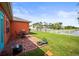 Inviting backyard with brick patio, outdoor seating, lush lawn, and scenic view of the pond beyond a white fence at 4194 Banbury Cir, Parrish, FL 34219