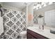 Bright bathroom featuring a shower with patterned curtain, dark wood vanity, and a framed mirror at 4194 Banbury Cir, Parrish, FL 34219