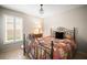 Charming bedroom featuring a decorative chandelier, a cozy quilt, and bright natural light from shuttered windows at 4194 Banbury Cir, Parrish, FL 34219