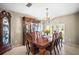 Formal dining area with wooden table, chairs, china cabinet, decorative chandelier, and tiled floor at 4194 Banbury Cir, Parrish, FL 34219