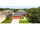 Aerial view of the home with a spacious driveway and mature landscaping next to water at 4194 Banbury Cir, Parrish, FL 34219