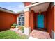 Inviting porch showcasing a bright blue door, manicured landscaping, and unique hanging lantern at 4194 Banbury Cir, Parrish, FL 34219