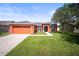 Well maintained single Gathering home with a 2 car garage, manicured lawn, and vibrant orange exterior at 4194 Banbury Cir, Parrish, FL 34219