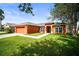 Charming one story home with a blue front door, orange exterior paint and well-maintained lawn at 4194 Banbury Cir, Parrish, FL 34219