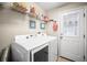 Functional laundry room with modern Samsung washer and dryer, wire shelving for storage, and decorative glass door at 4194 Banbury Cir, Parrish, FL 34219