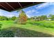 A lush backyard view from under the covered patio features mature trees and pond for a tranquil escape at 4227 Placid Dr, Sarasota, FL 34243