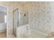 Bathroom featuring a glass enclosed shower, soaking tub with tile surround, and neutral wall coverings at 4227 Placid Dr, Sarasota, FL 34243