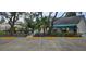 Exterior shot of a community pool area with parking and a white building with a turquoise awning at 4227 Placid Dr, Sarasota, FL 34243