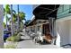 Charming outdoor restaurant seating area with black and white decor, under a striped awning, lined with palm trees at 4227 Placid Dr, Sarasota, FL 34243